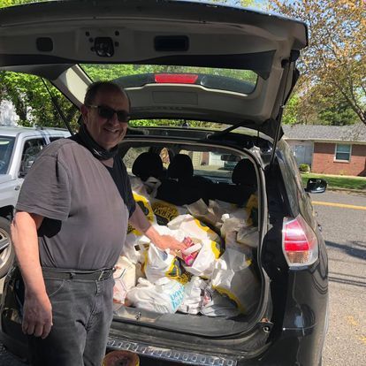 man loading trunk with food
