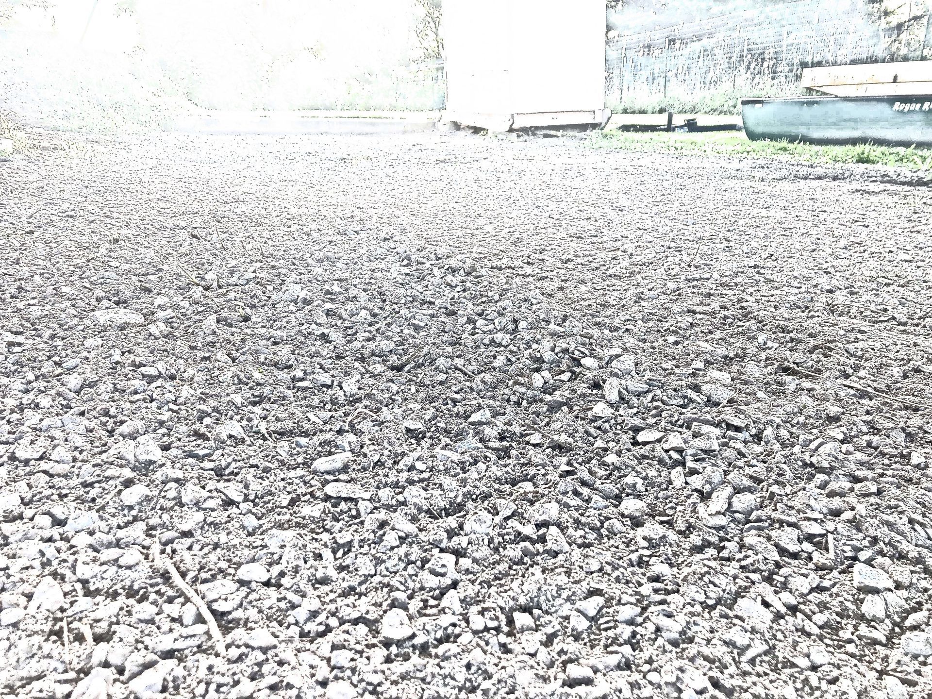A black and white photo of a gravel road.