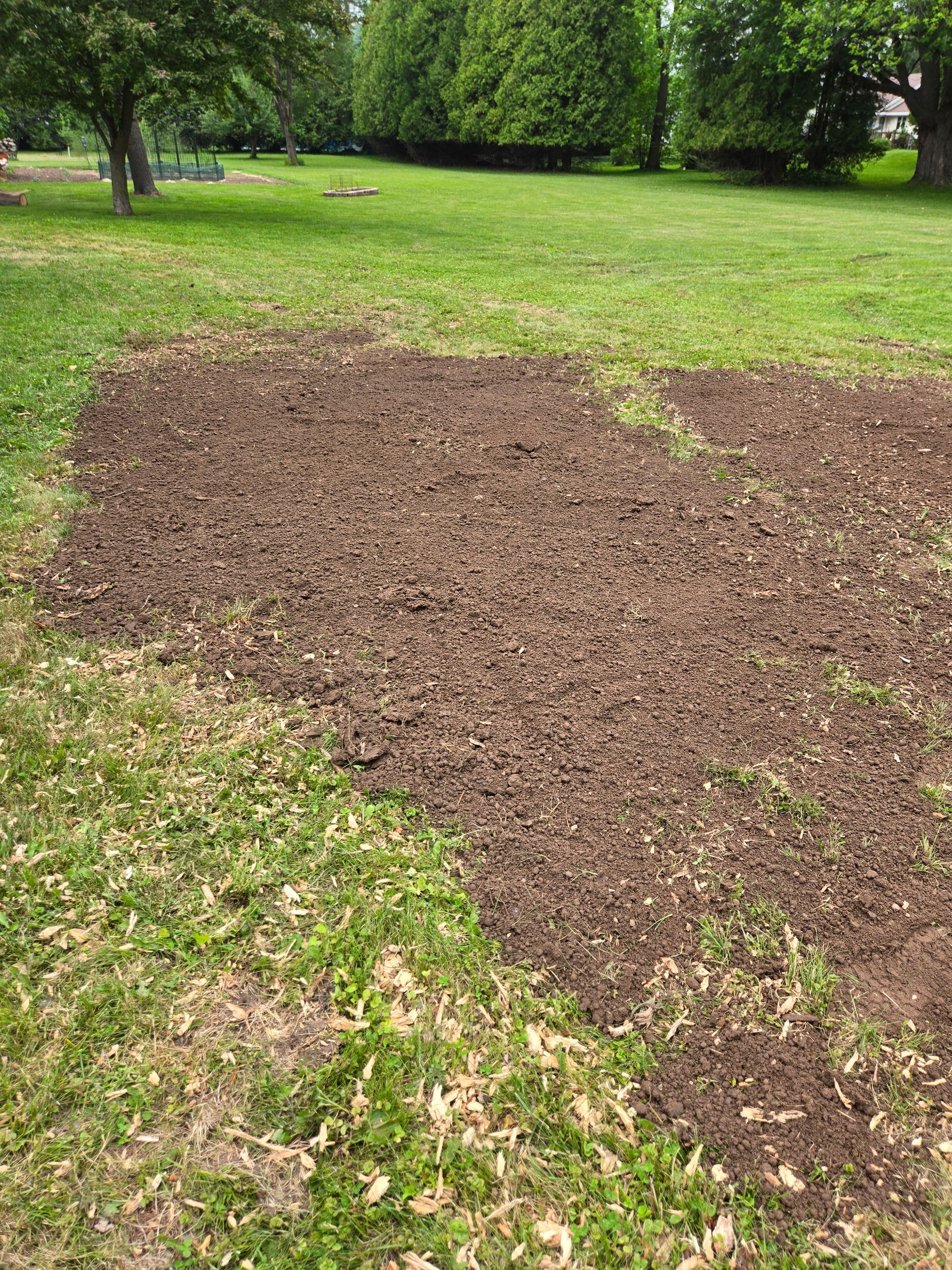 A pile of dirt is sitting on top of a lush green field.