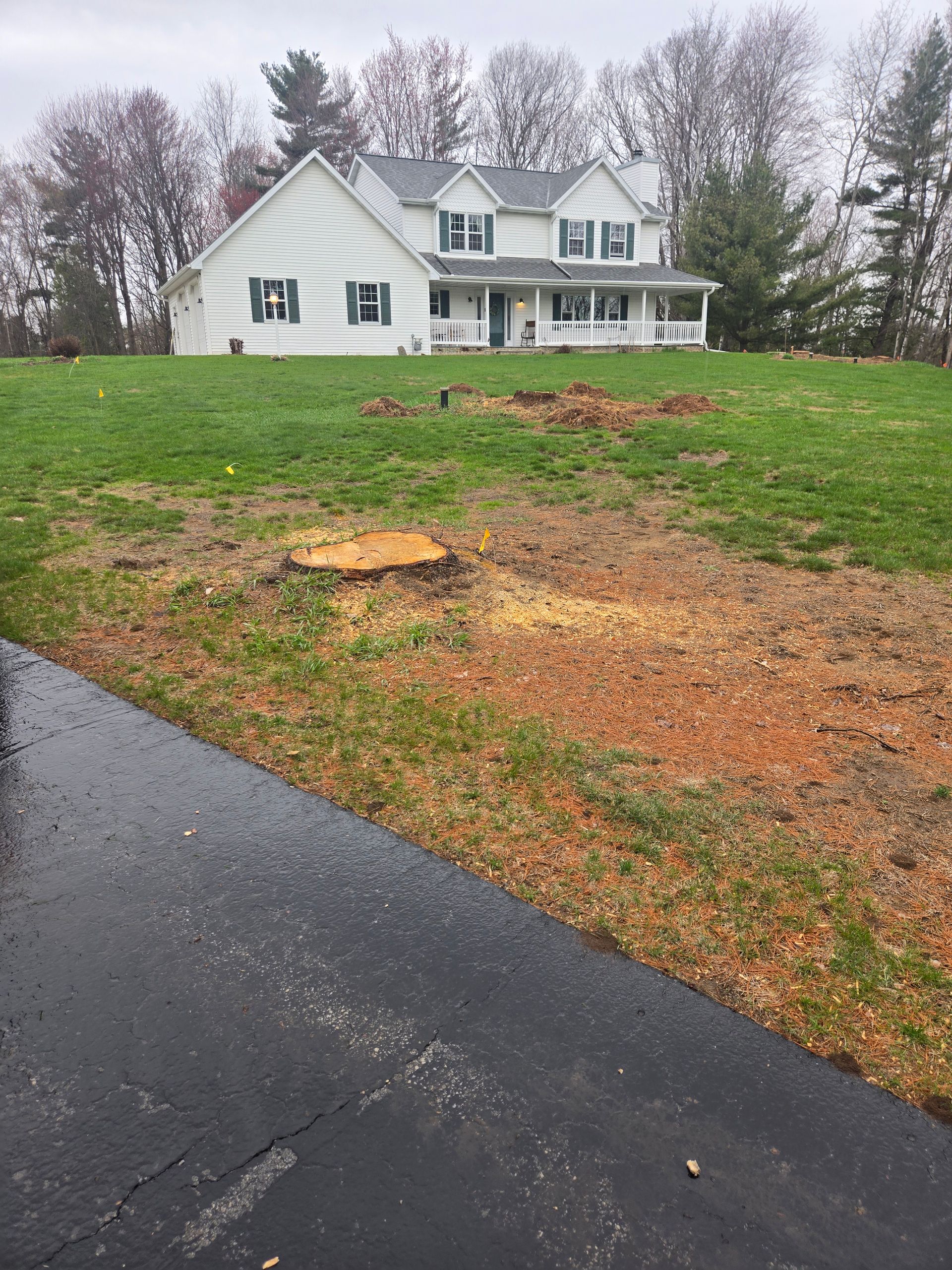 A large white house is sitting on top of a lush green field.