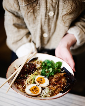 Teller mit vegetarischem Essen und Essstäbchen