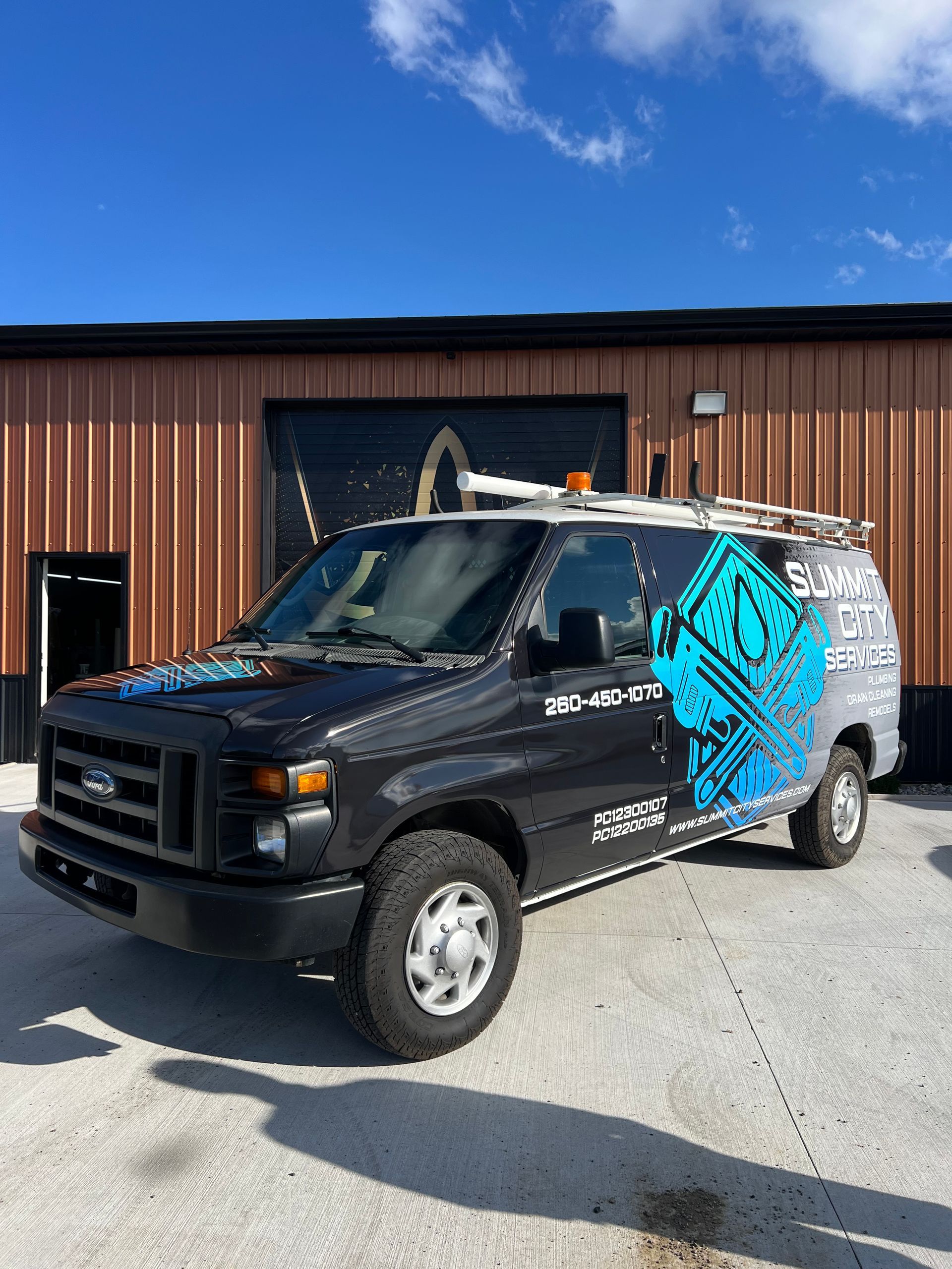 A blue and orange van is parked in a parking lot