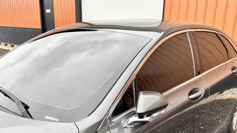 A car is parked in front of a building with a garage door.