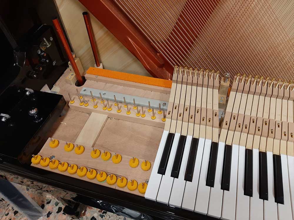 Un primo piano della tastiera di un pianoforte che mostra i tasti