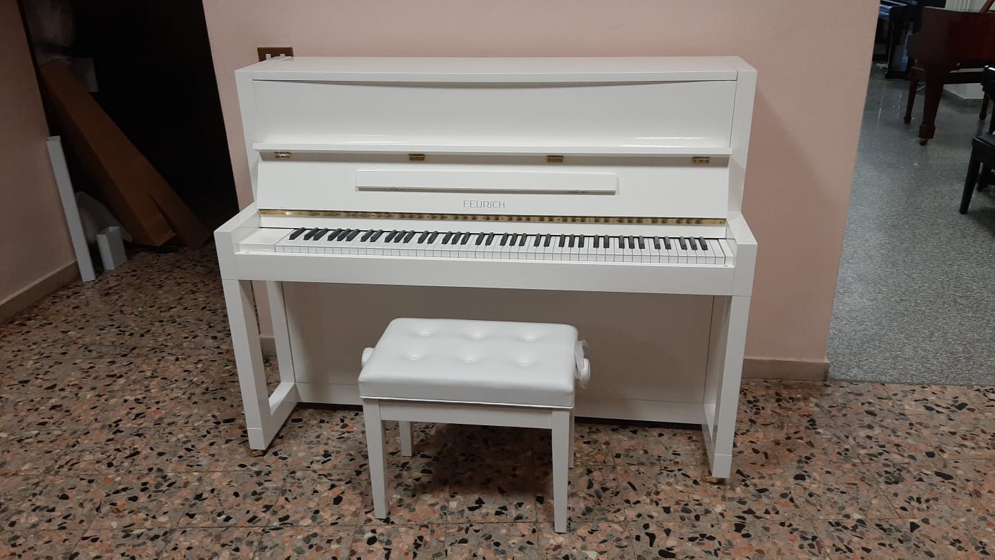 Un pianoforte bianco con una panca accanto