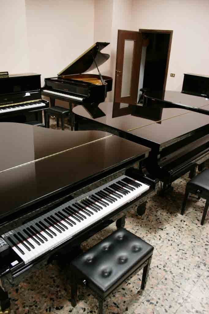 Un gruppo di pianoforti sono allineati in una stanza