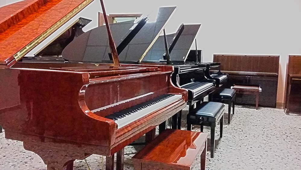 Una fila di pianoforti sono allineati in una stanza