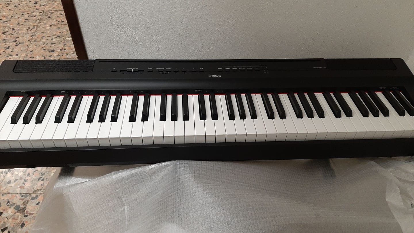 Una tastiera di pianoforte in bianco e nero è appoggiata su un tavolo