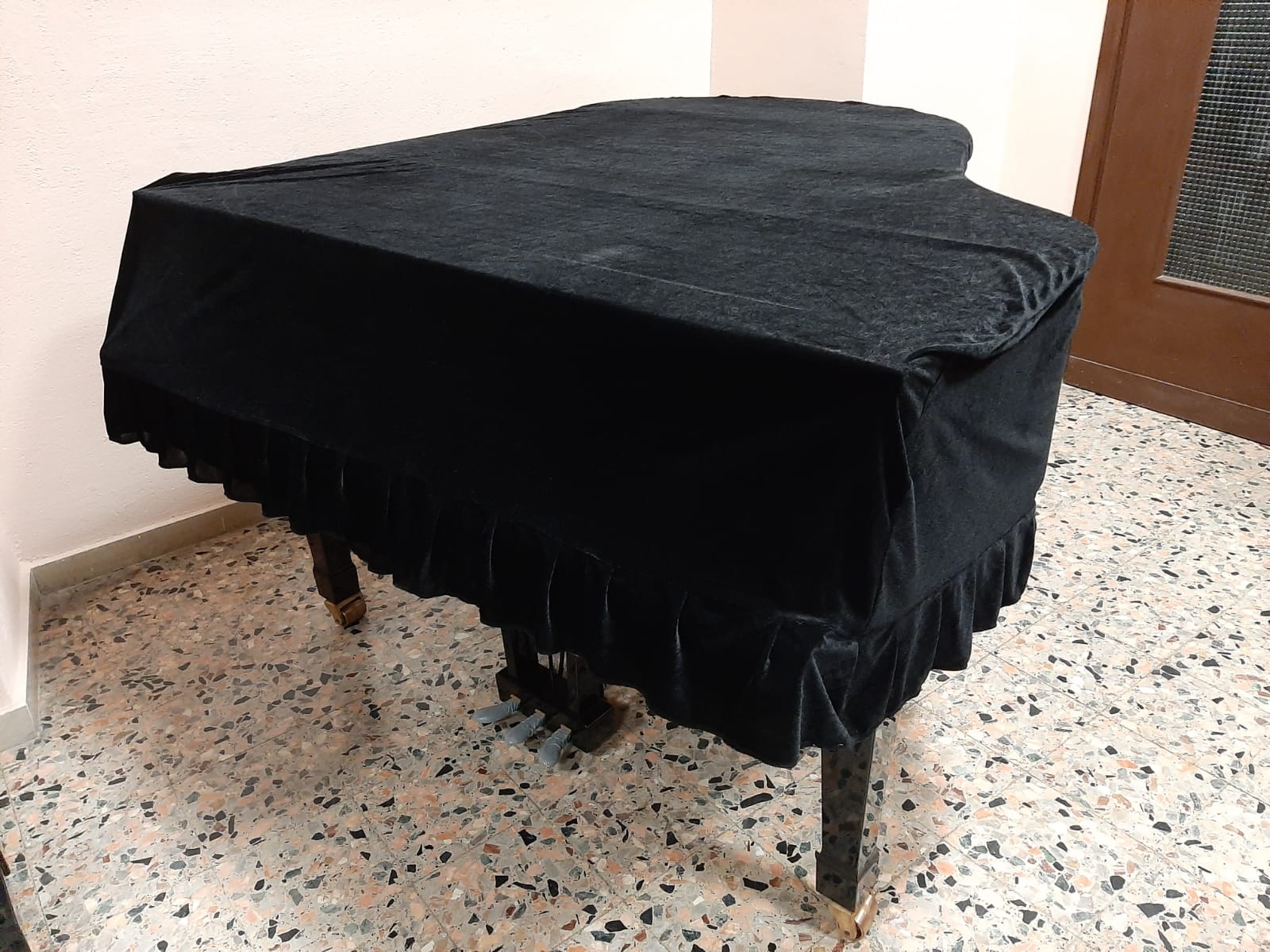 Un pianoforte nero con una copertina nera