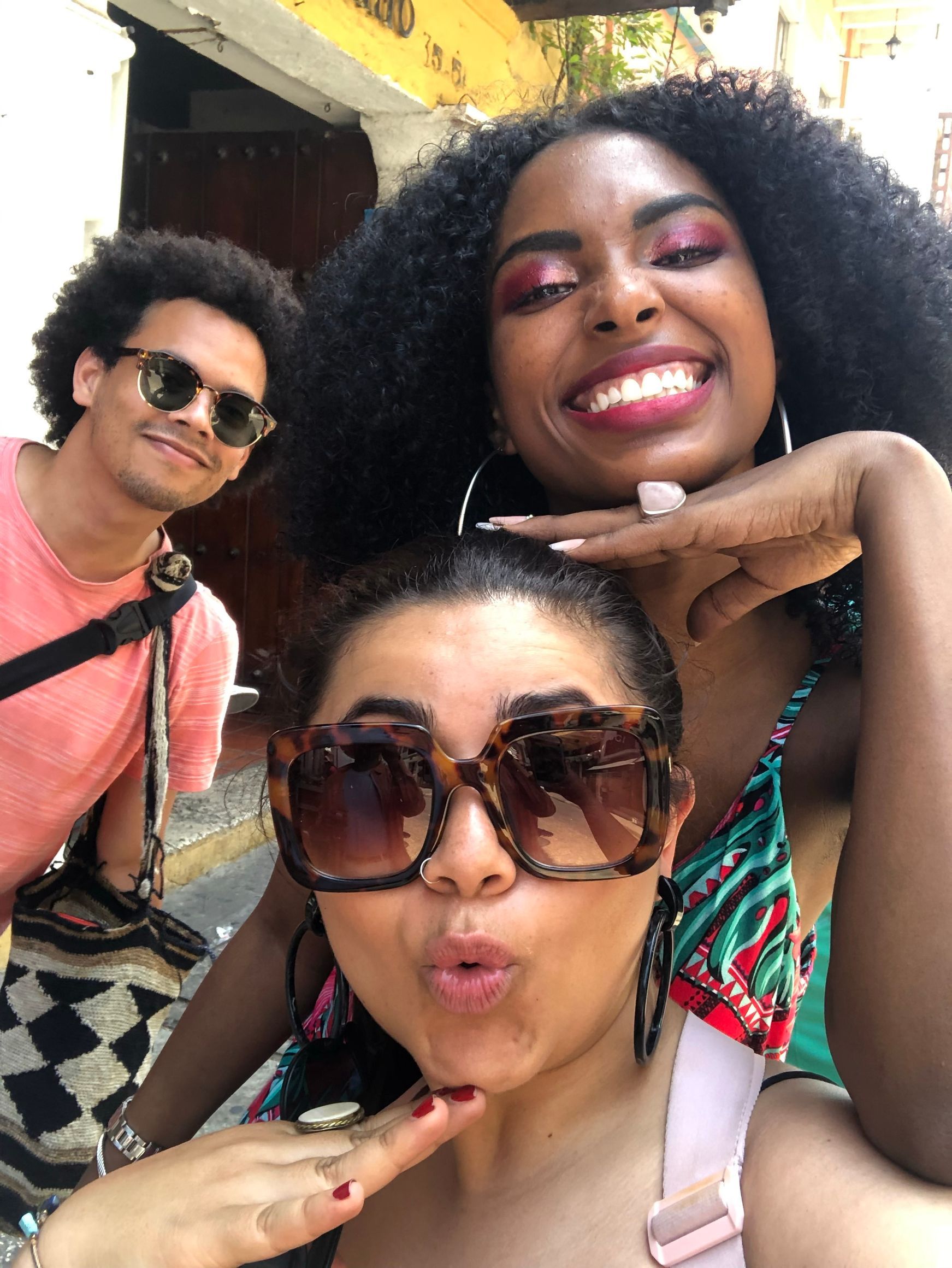 Tres personas posando para una foto, una de ellas con gafas de sol.