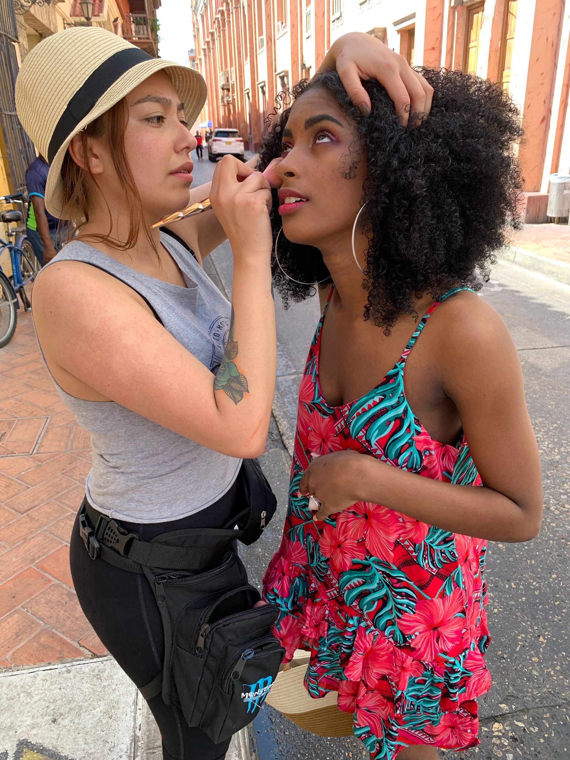 Una mujer está aplicando maquillaje en la cara de otra mujer.