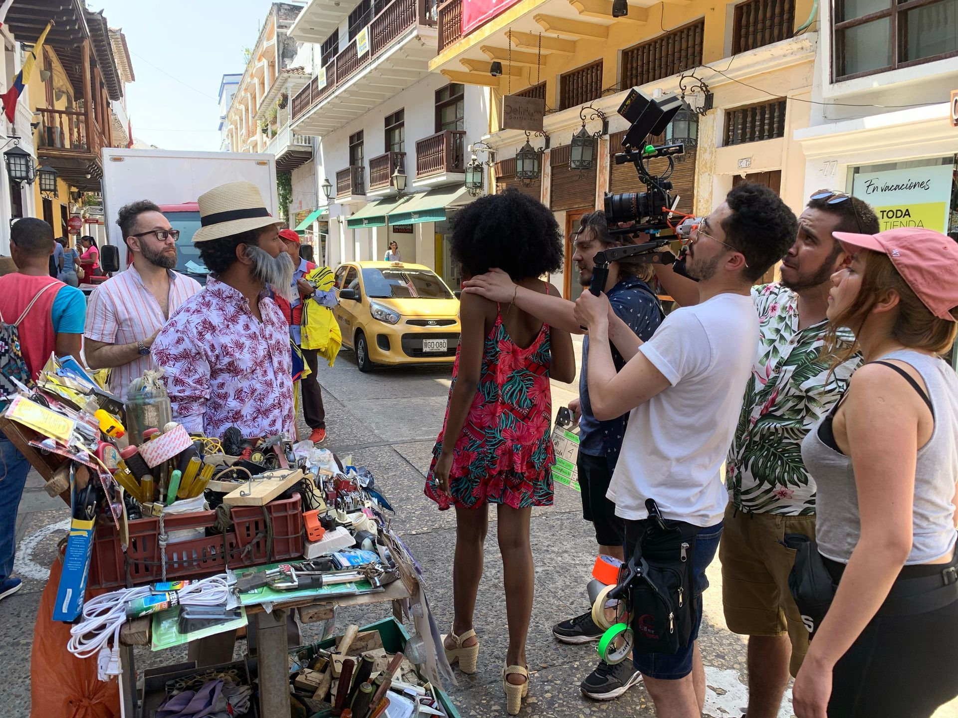Un grupo de personas está de pie alrededor de una mujer en una calle.