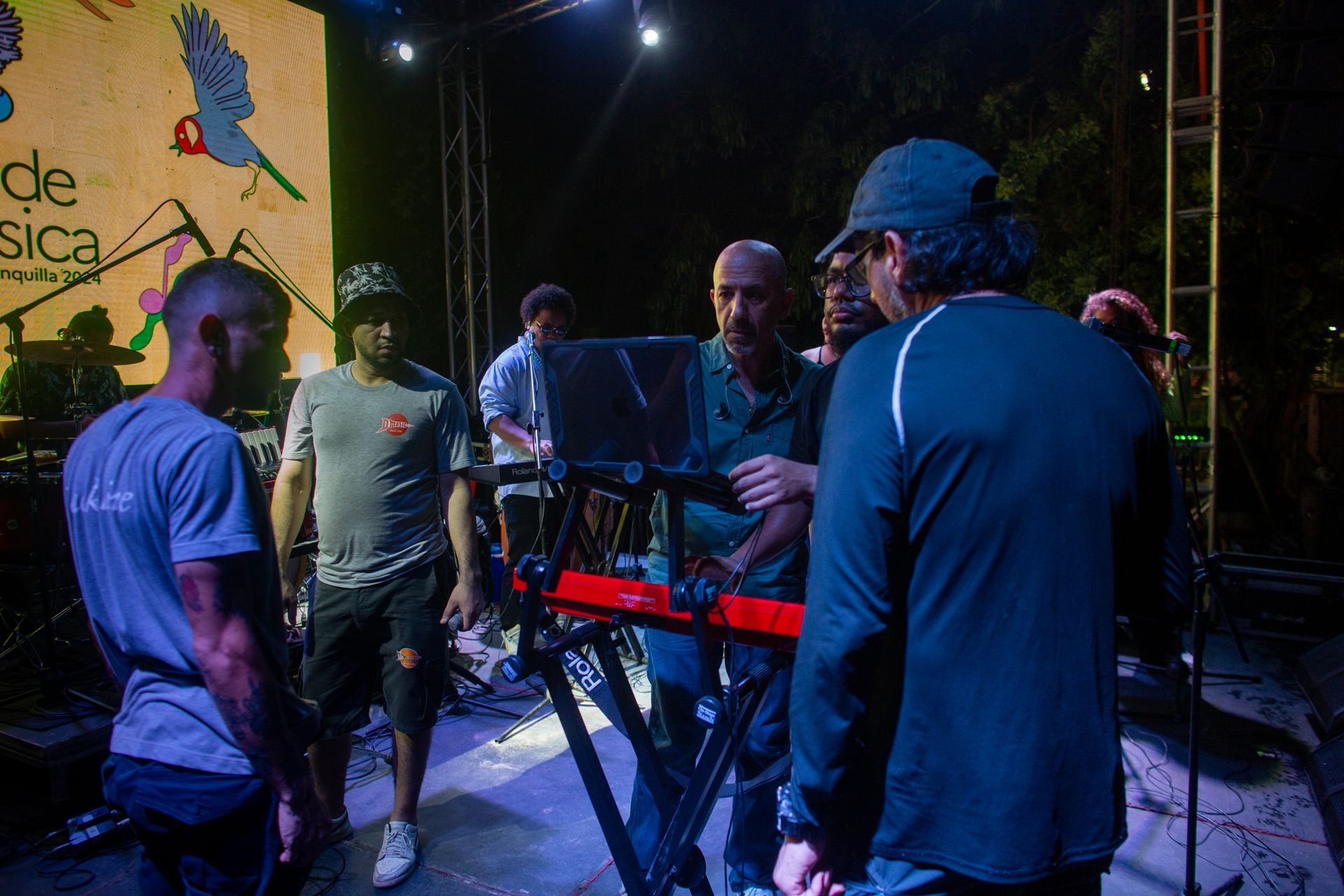 Un grupo de hombres están de pie alrededor de un teclado en un escenario.