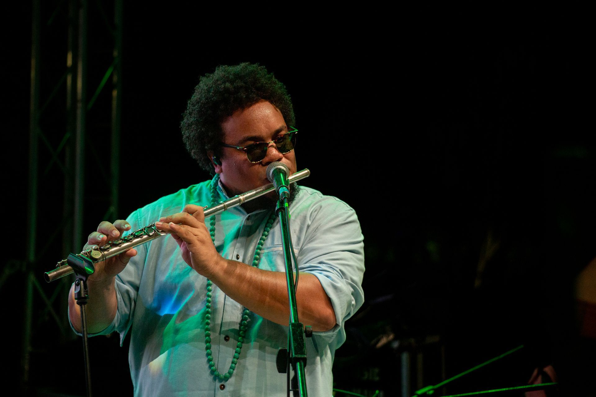 Un hombre está tocando una flauta delante de un micrófono.