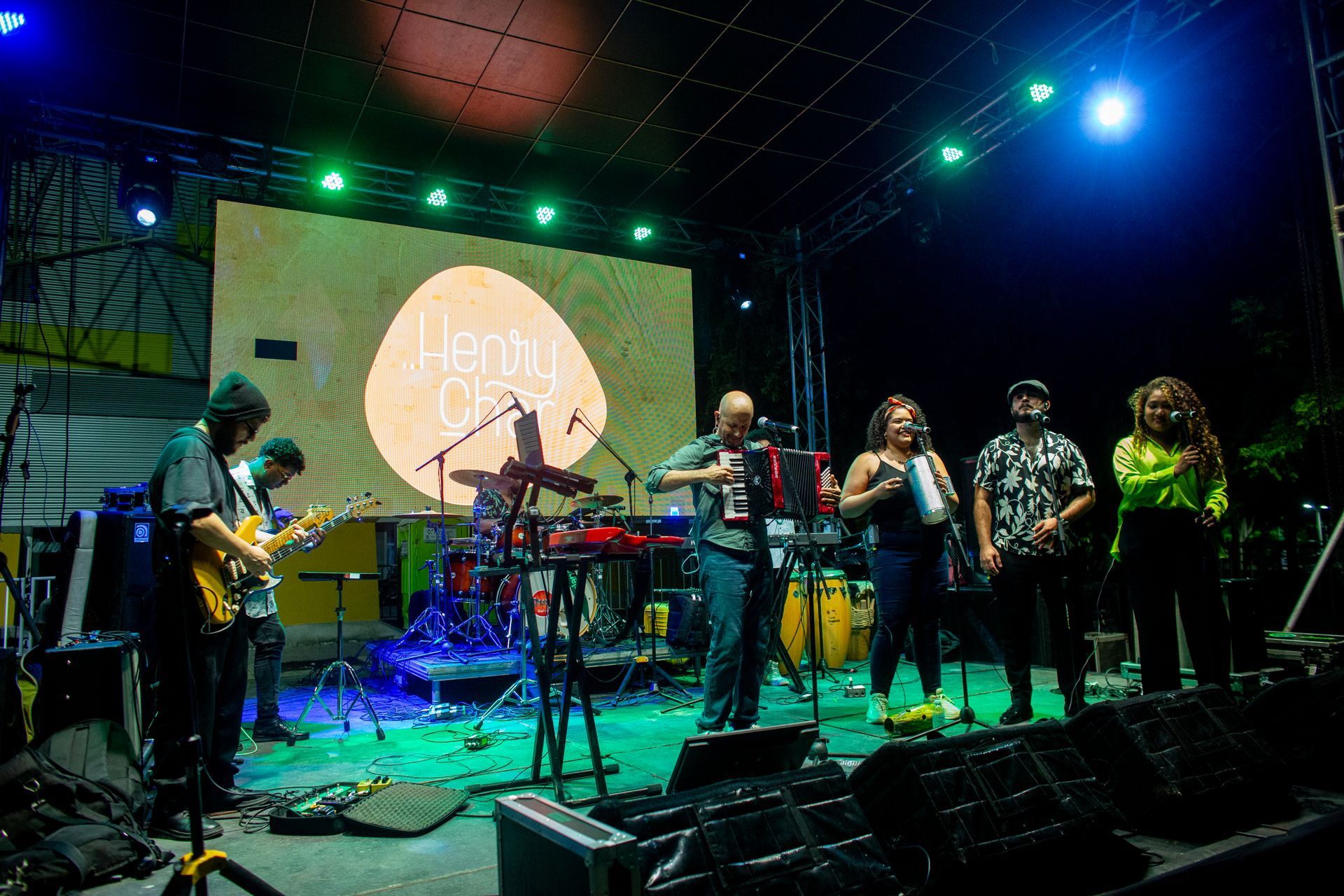 Un grupo de personas está de pie en un escenario tocando instrumentos.