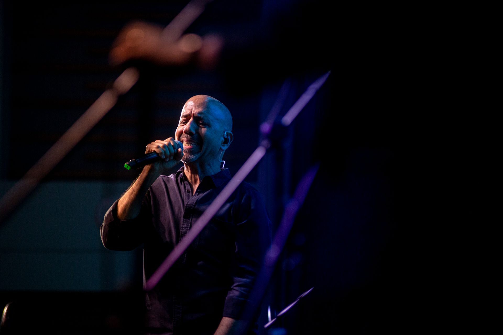Un hombre está cantando en un micrófono en un escenario.