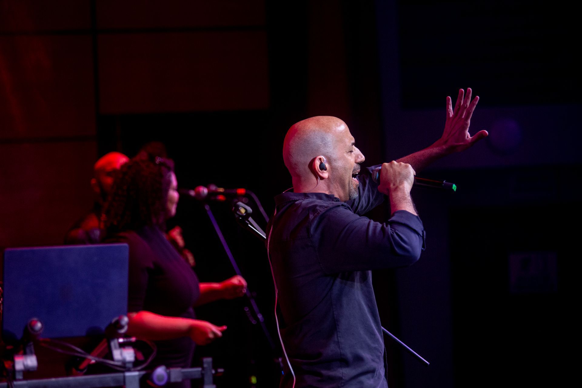 Un hombre está cantando en un micrófono en un escenario.