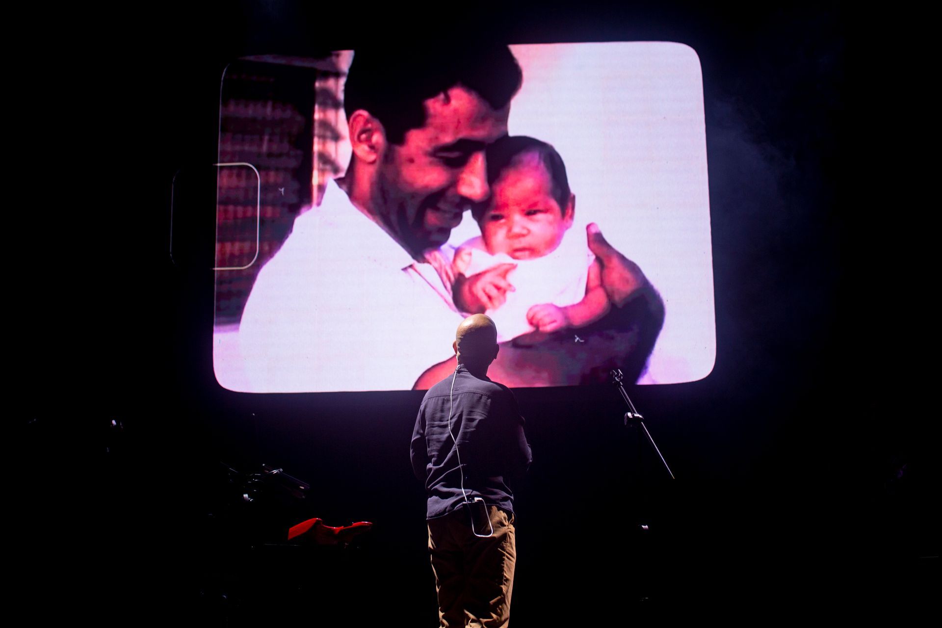 Un hombre está mirando una foto de un hombre sosteniendo un bebé.