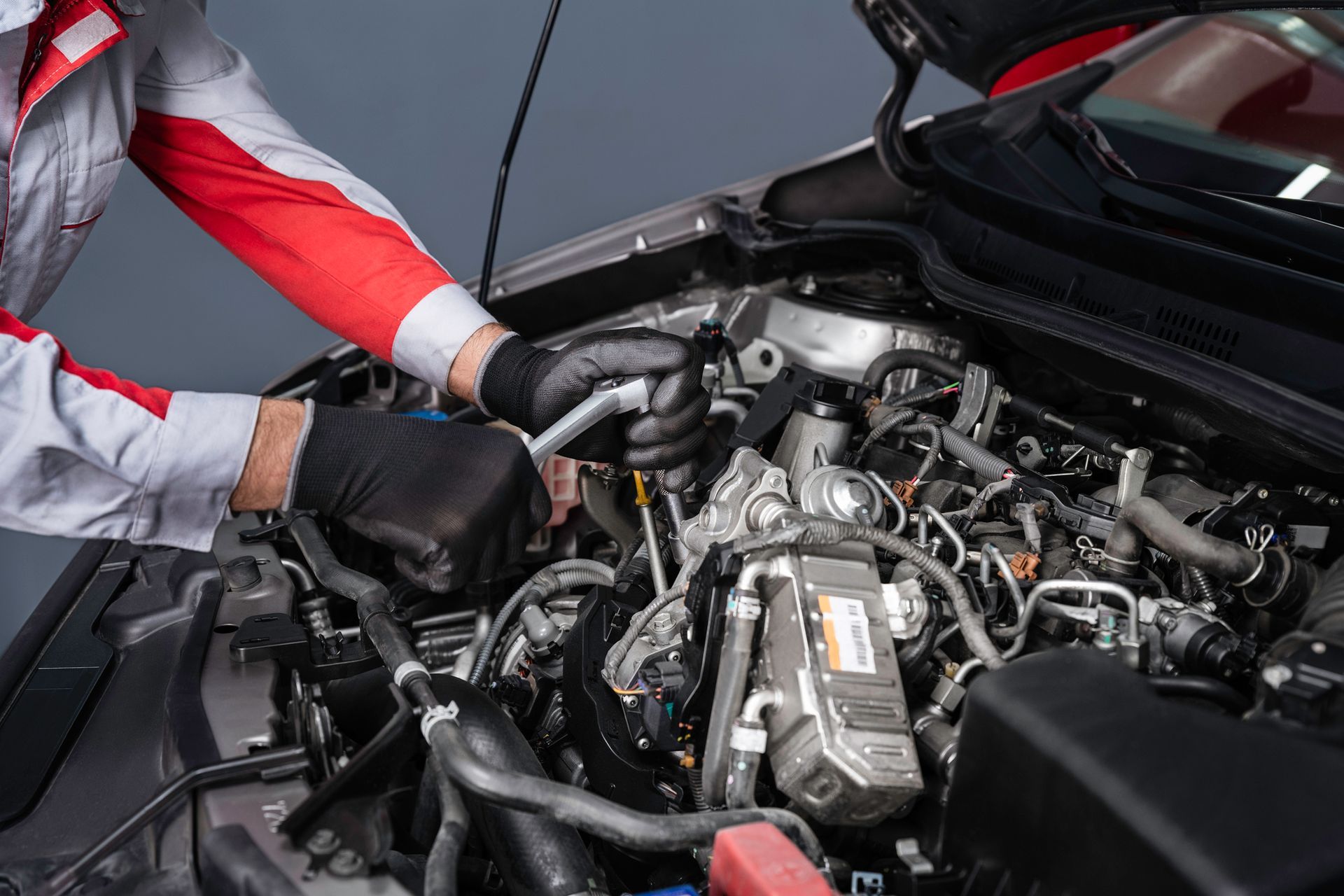 A mechanic is working on the engine of a car - Poway, CA - Freddie’s Domestic Import and Auto Service