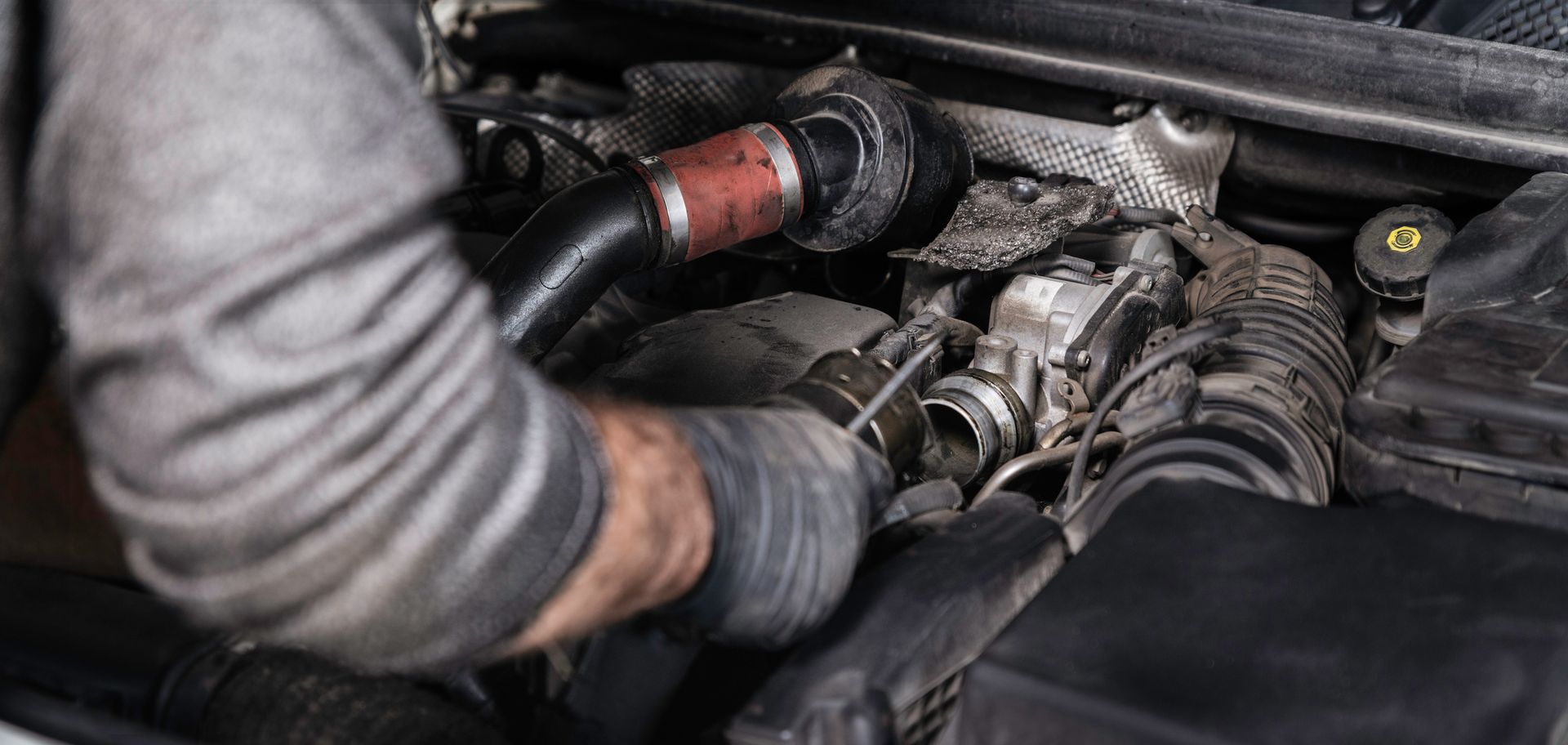 A man is working on the engine of a car - Poway, CA - Freddie’s Domestic Import and Auto Service