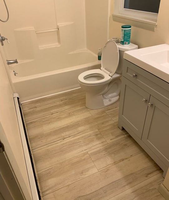 A bathroom with a toilet , sink , bathtub and shower.