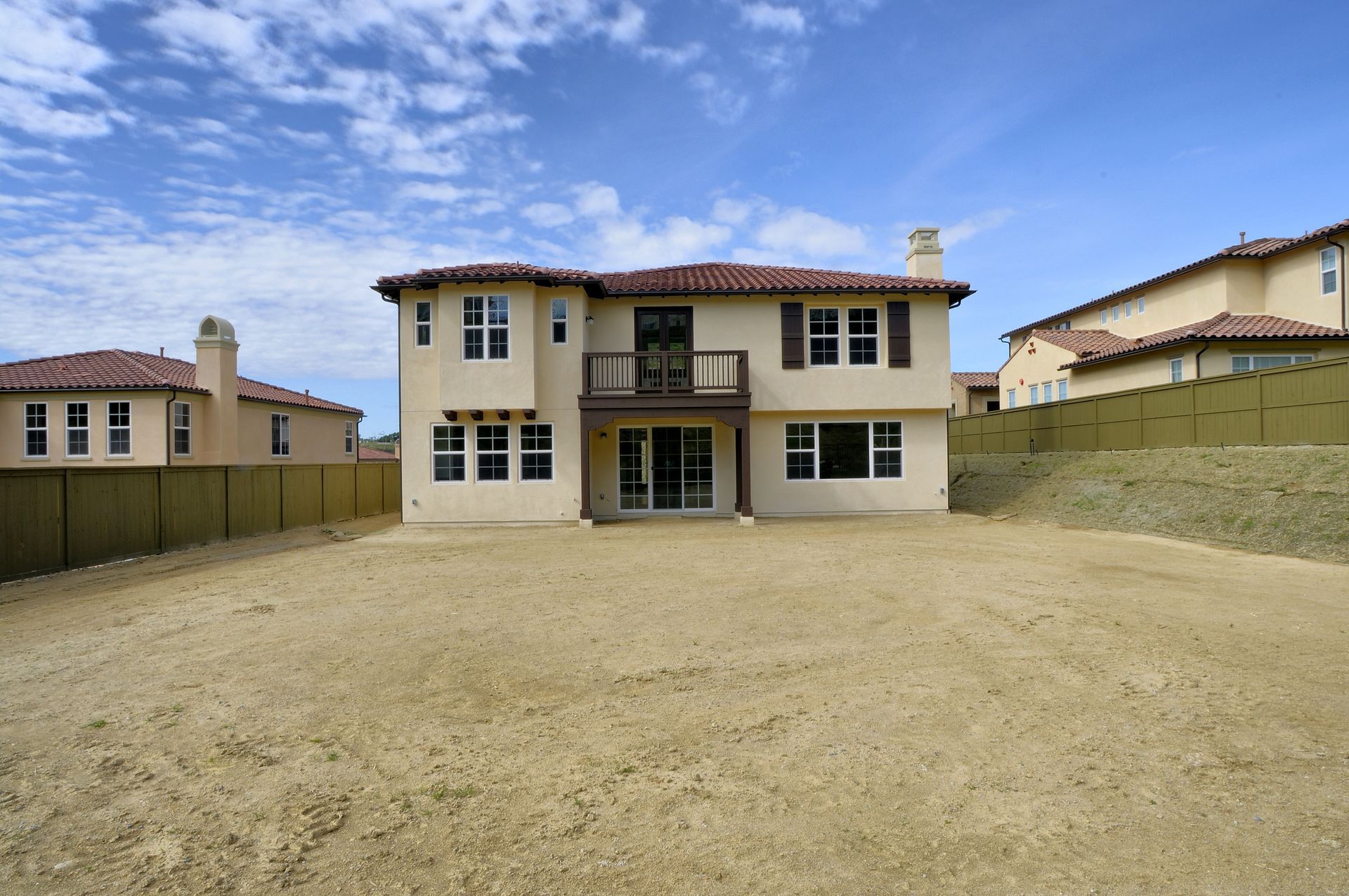 The backyard of a house with a lot of dirt in front of it