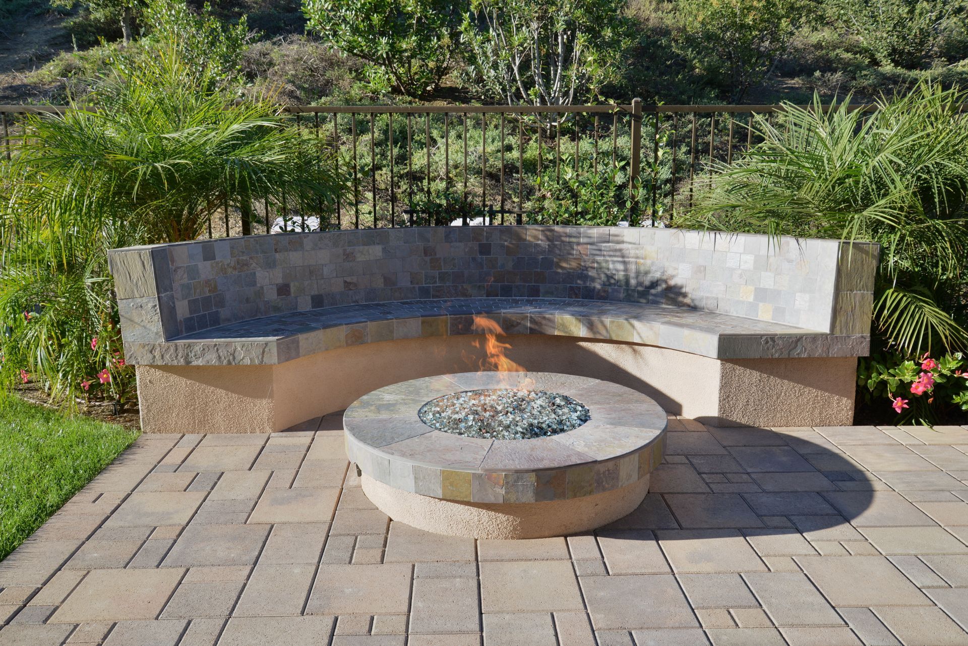 A fire pit is sitting next to a bench on a patio.