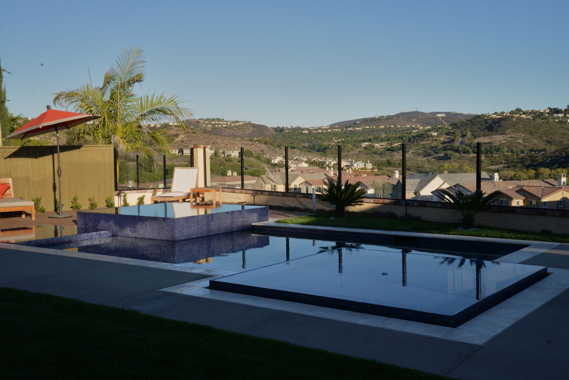 A large swimming pool in a backyard with a view of the mountains.