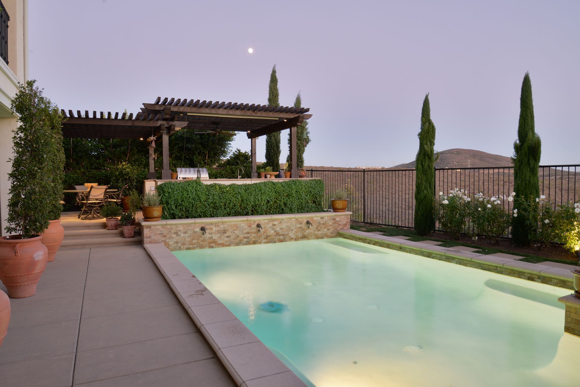 There is a large swimming pool in the backyard of a house.