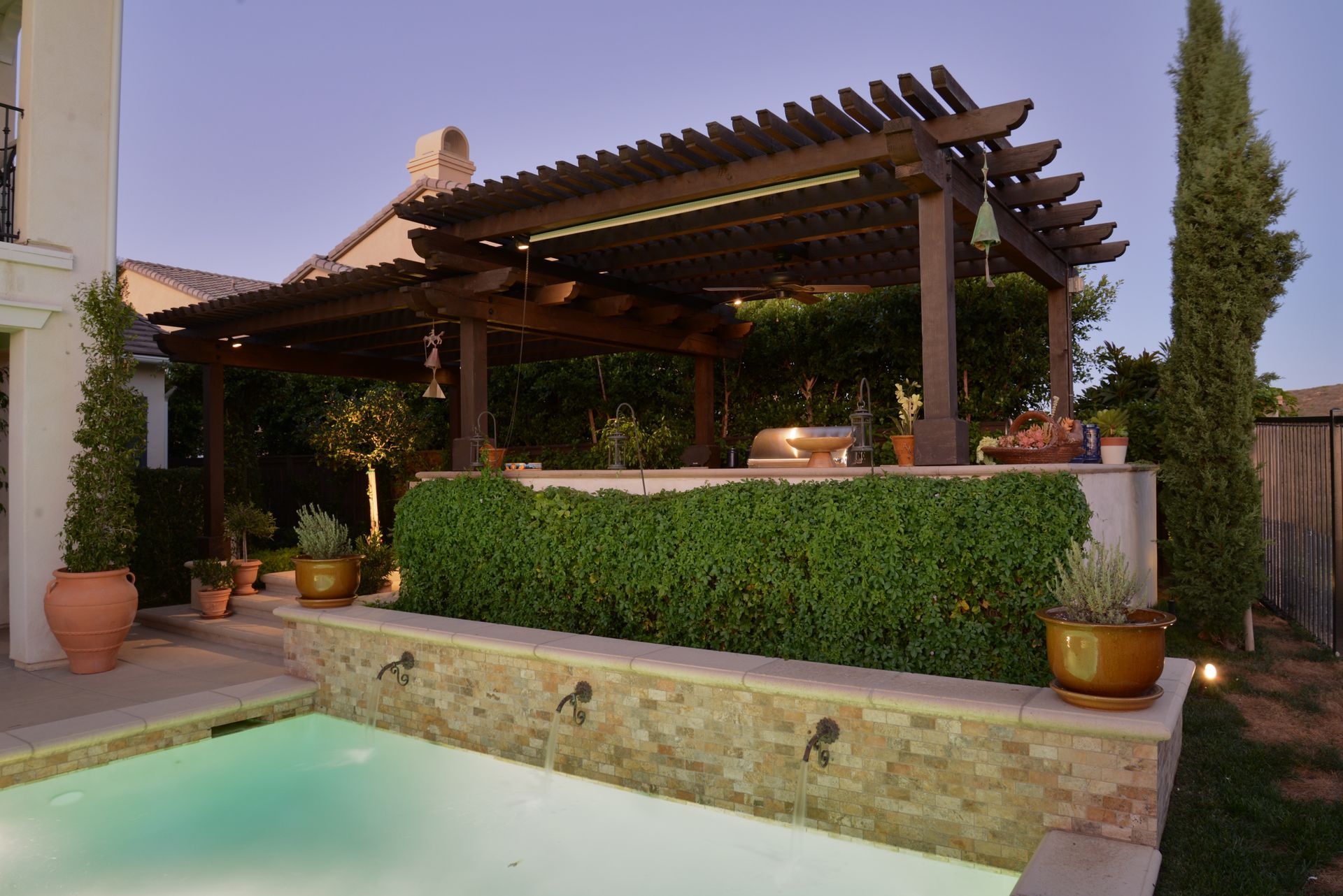 A large swimming pool with a pergola over it
