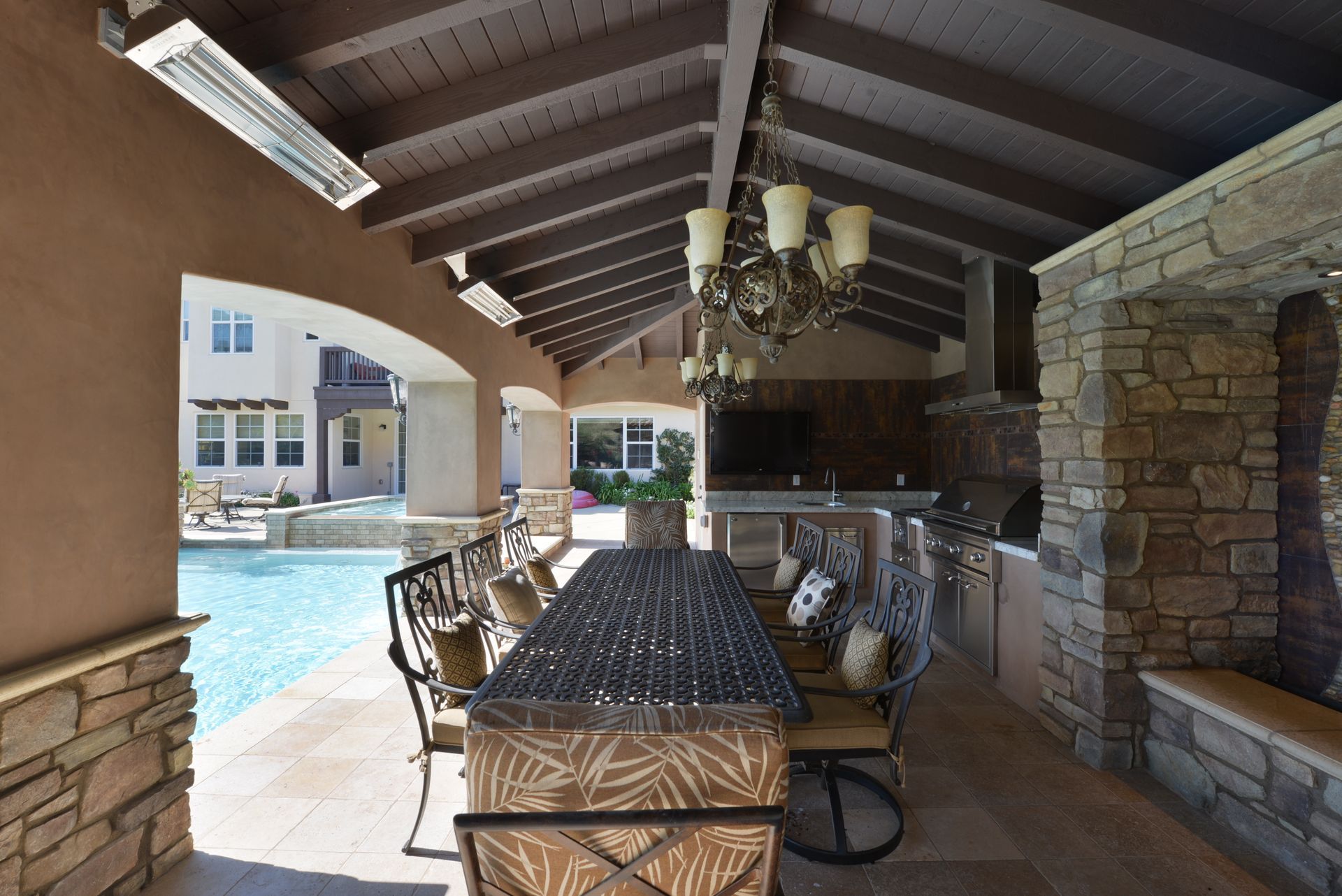 A patio area with a table and chairs next to a pool