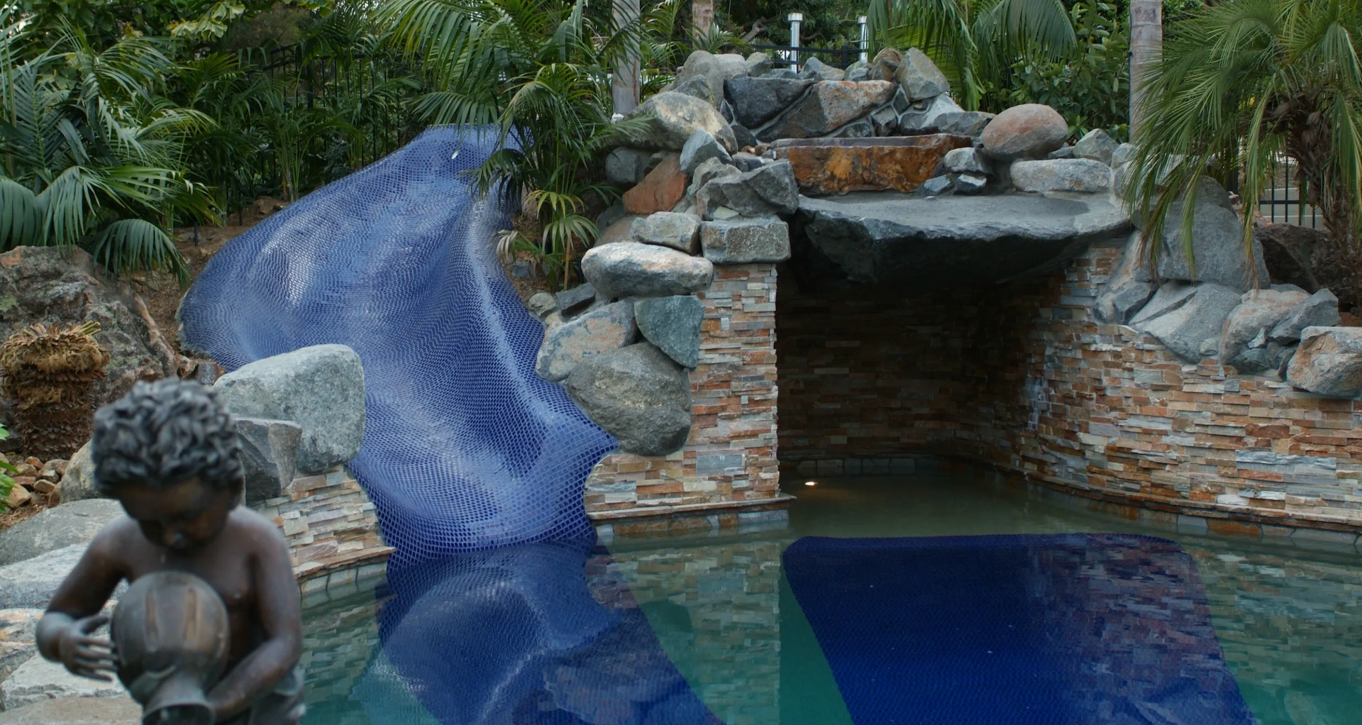 Custom built stone pool with built-in slide