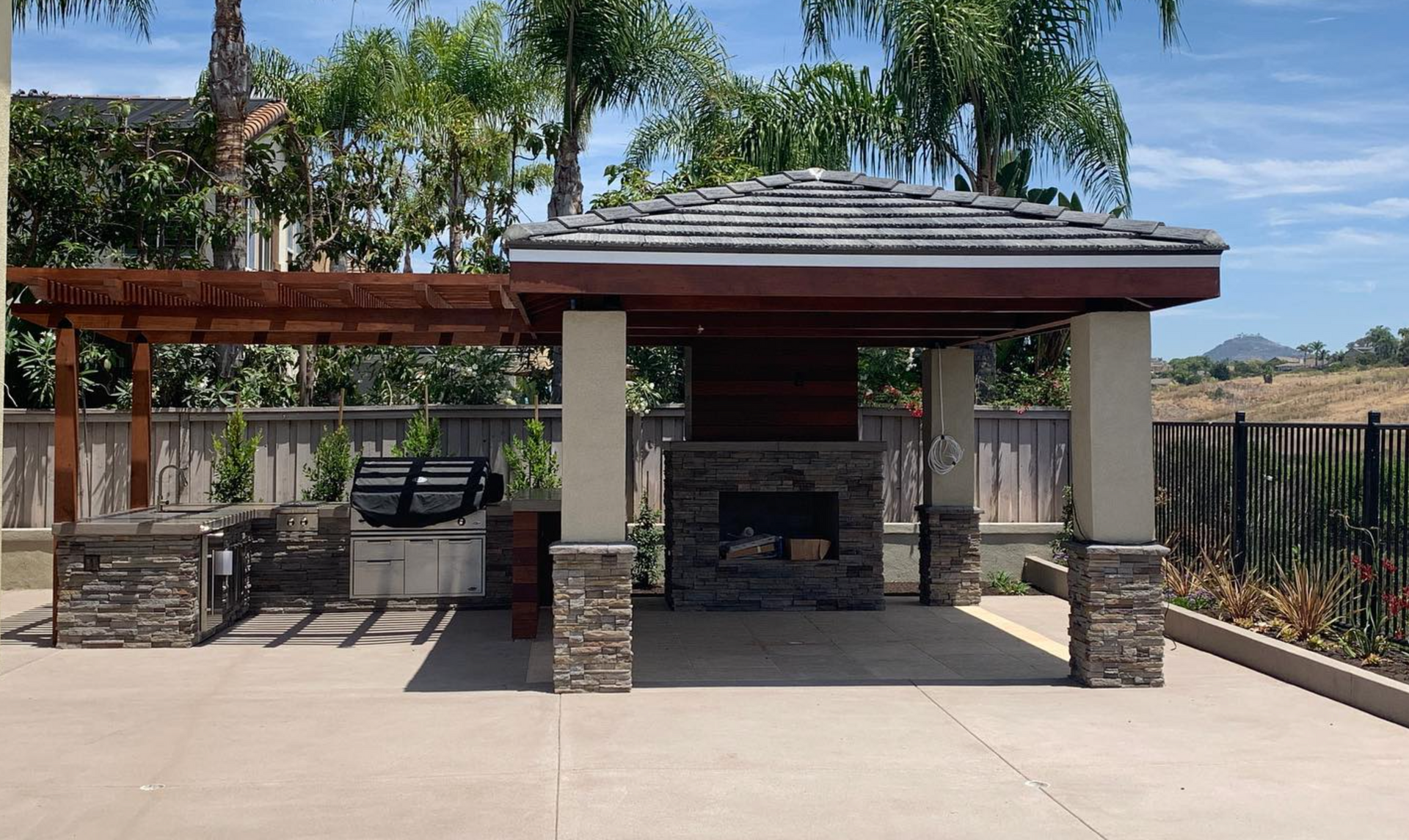 A gazebo with a fireplace and grill underneath it