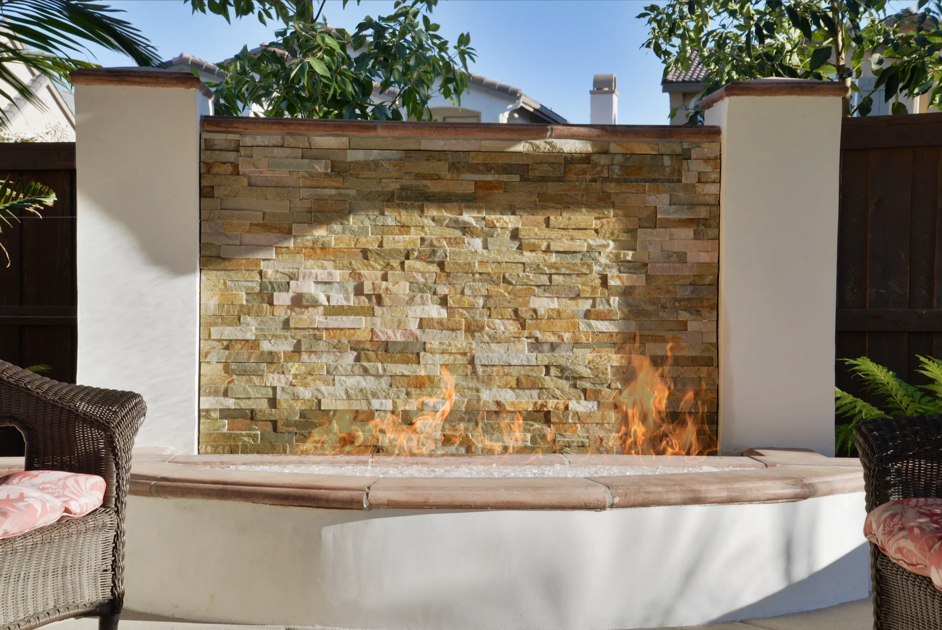 A stone wall with a fire pit in front of it