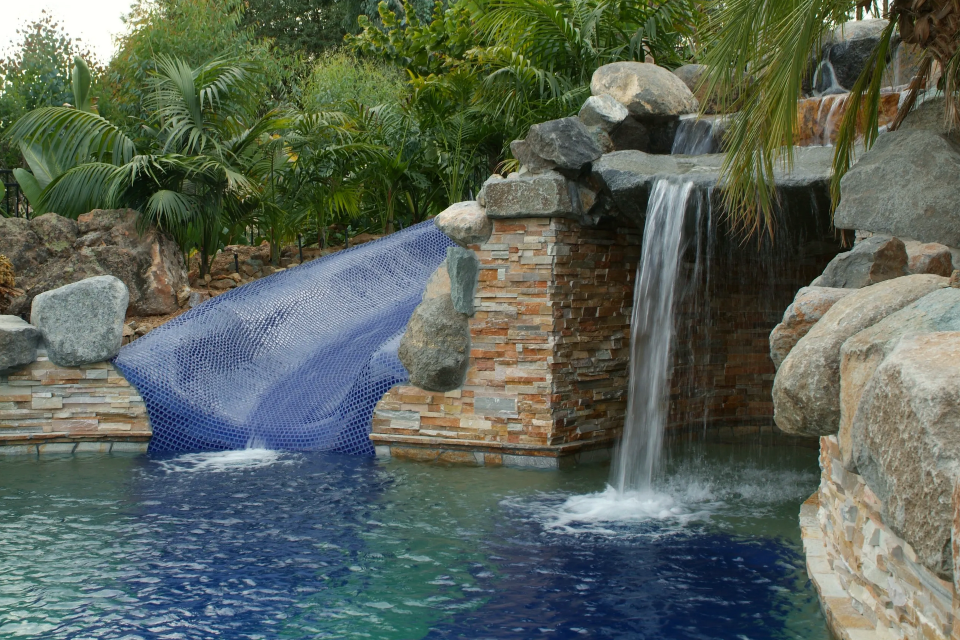 There is a waterfall in the middle of the pool.