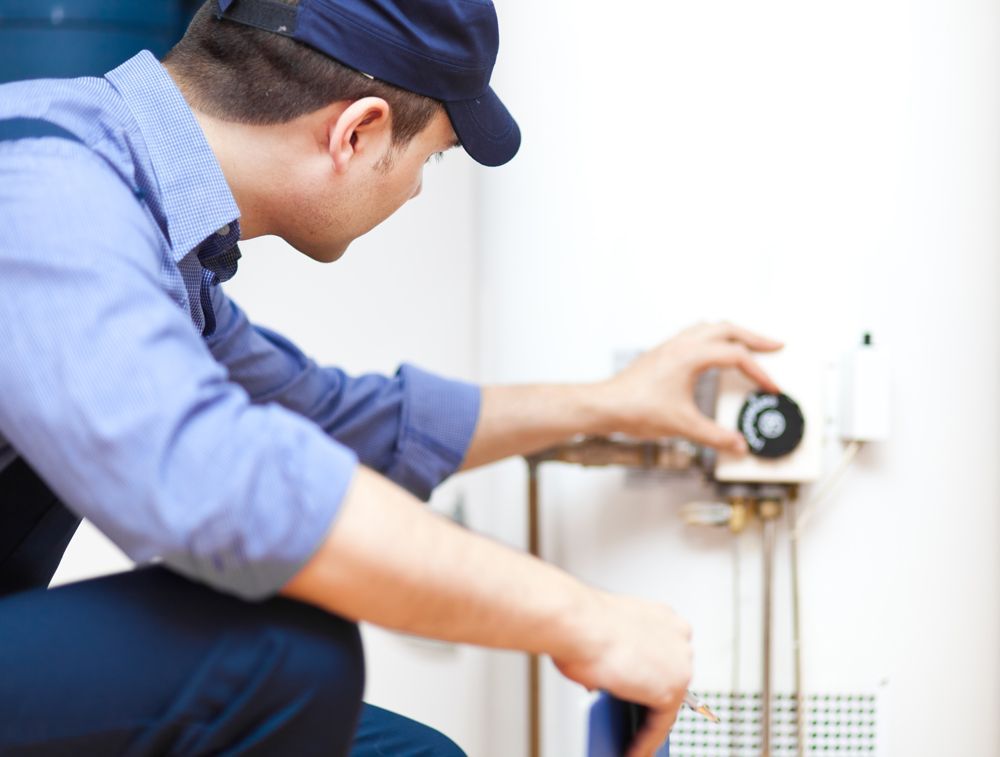 Plumber Adjusting the Heat of a Water Heater