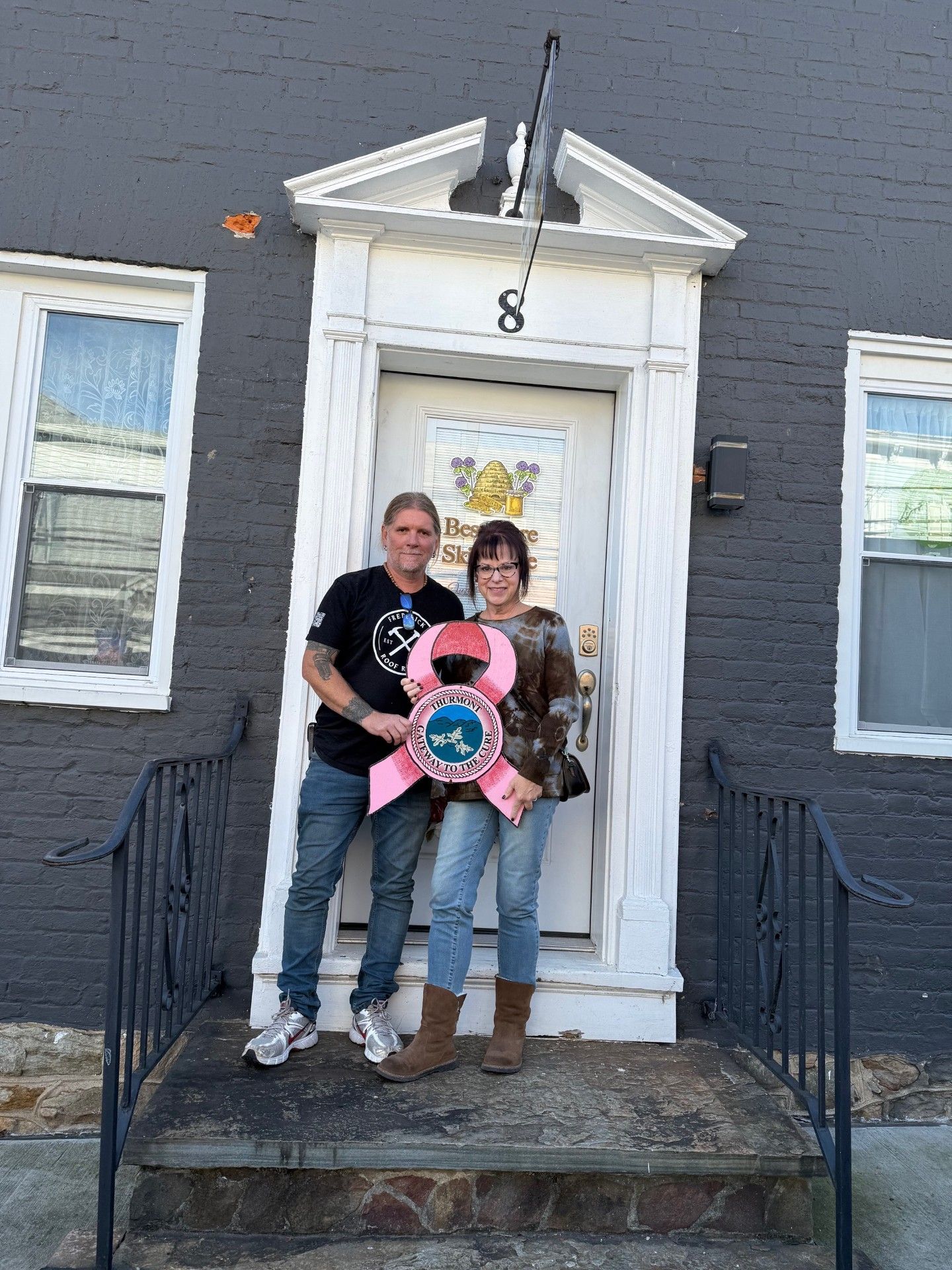 A woman wearing glasses is smiling and taking a selfie.