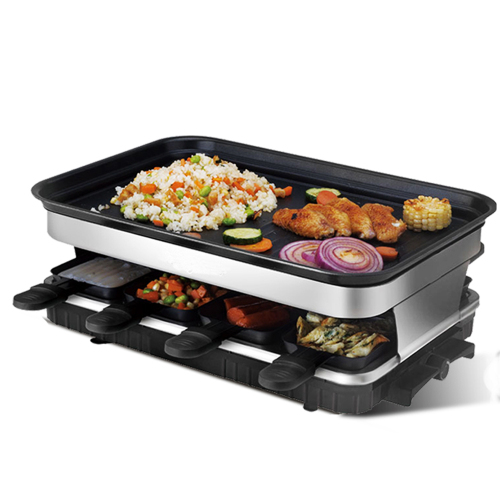 A rectangular raclette grill with a black cooking surface holding rice, meat, and vegetables, plus four lower mini-pans.