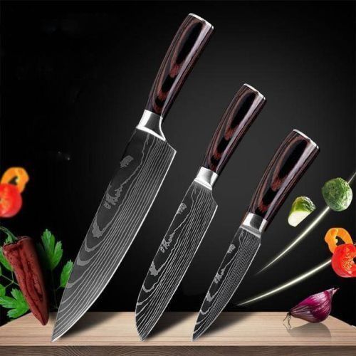 Three kitchen knives with dark wood handles and patterned blades displayed against a black background with vegetables.