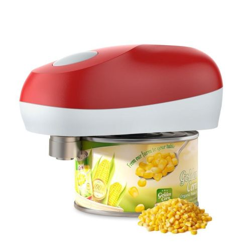 An electric, red-and-white can opener sits atop a can of corn next to a small pile of loose corn kernels.