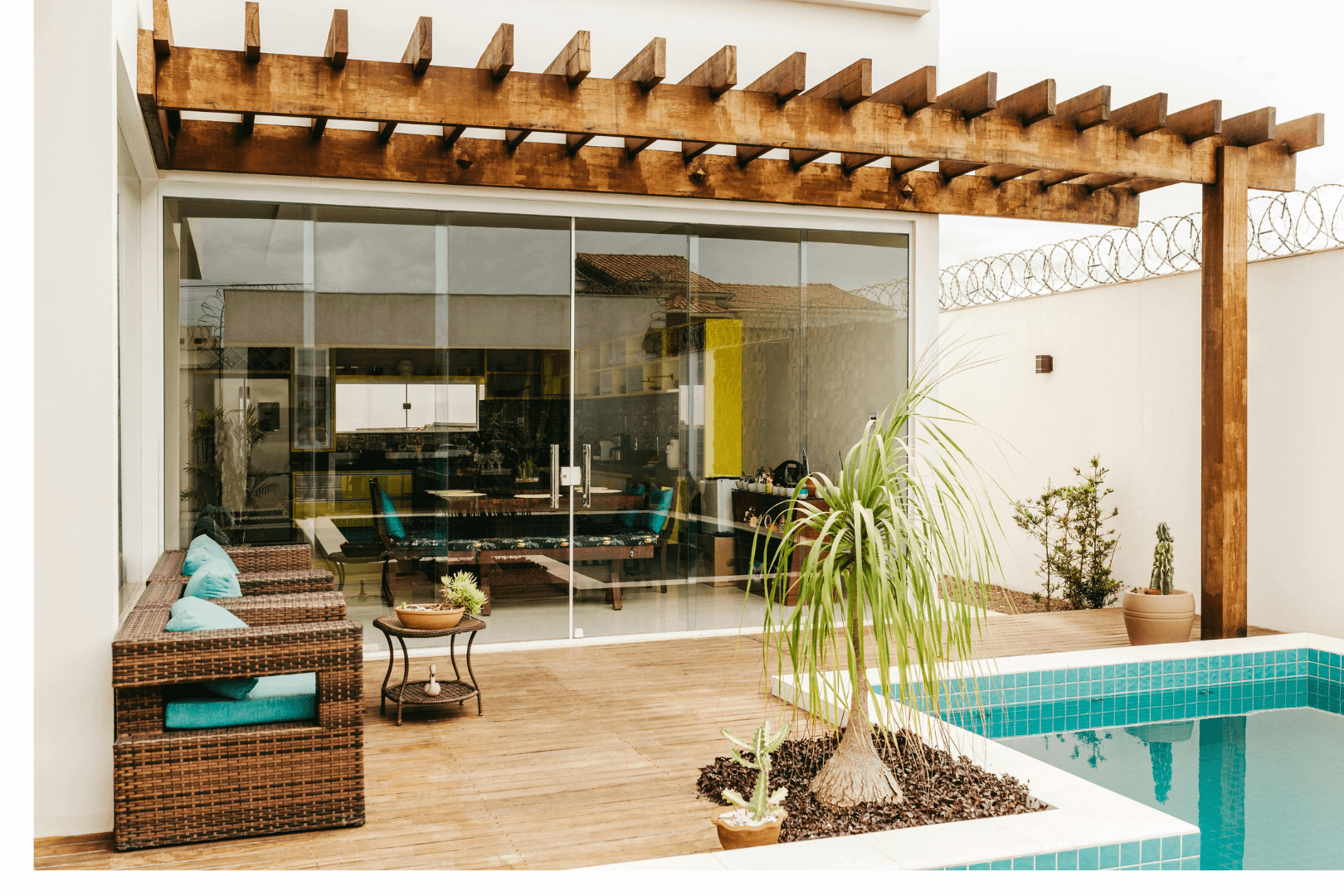 A dark blue house with a white garage door and a long concrete driveway against a clear blue sky.