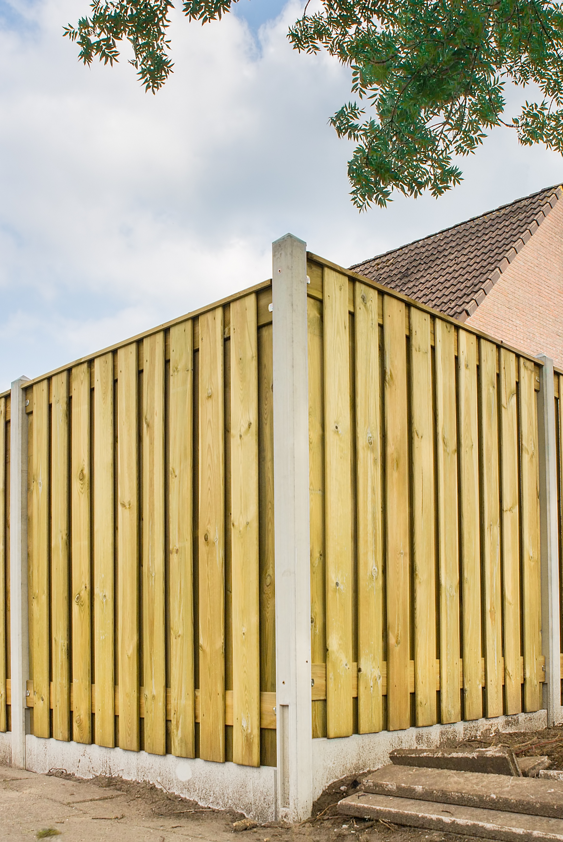 A wooden fence is surrounded by concrete steps and a brick building. Jarvis & Son Renovations,
