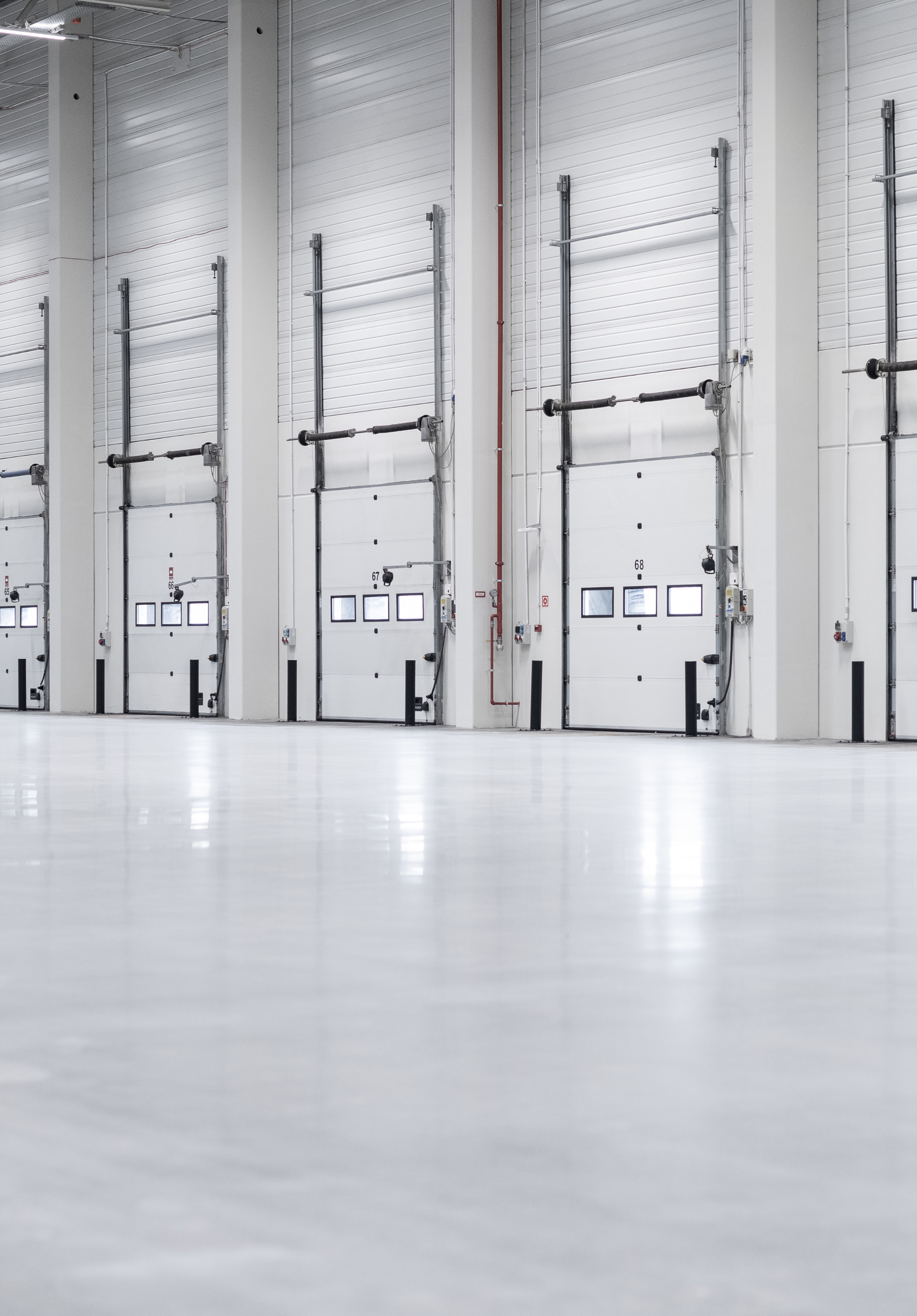 A large warehouse with a lot of doors and a concrete floor cleaned. Jarvis & Son Renovations,