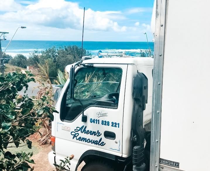 A White Truck Is Parked On The Side Of The Road In Front Of The Ocean — Ahern's Removals In Grafton, NSW