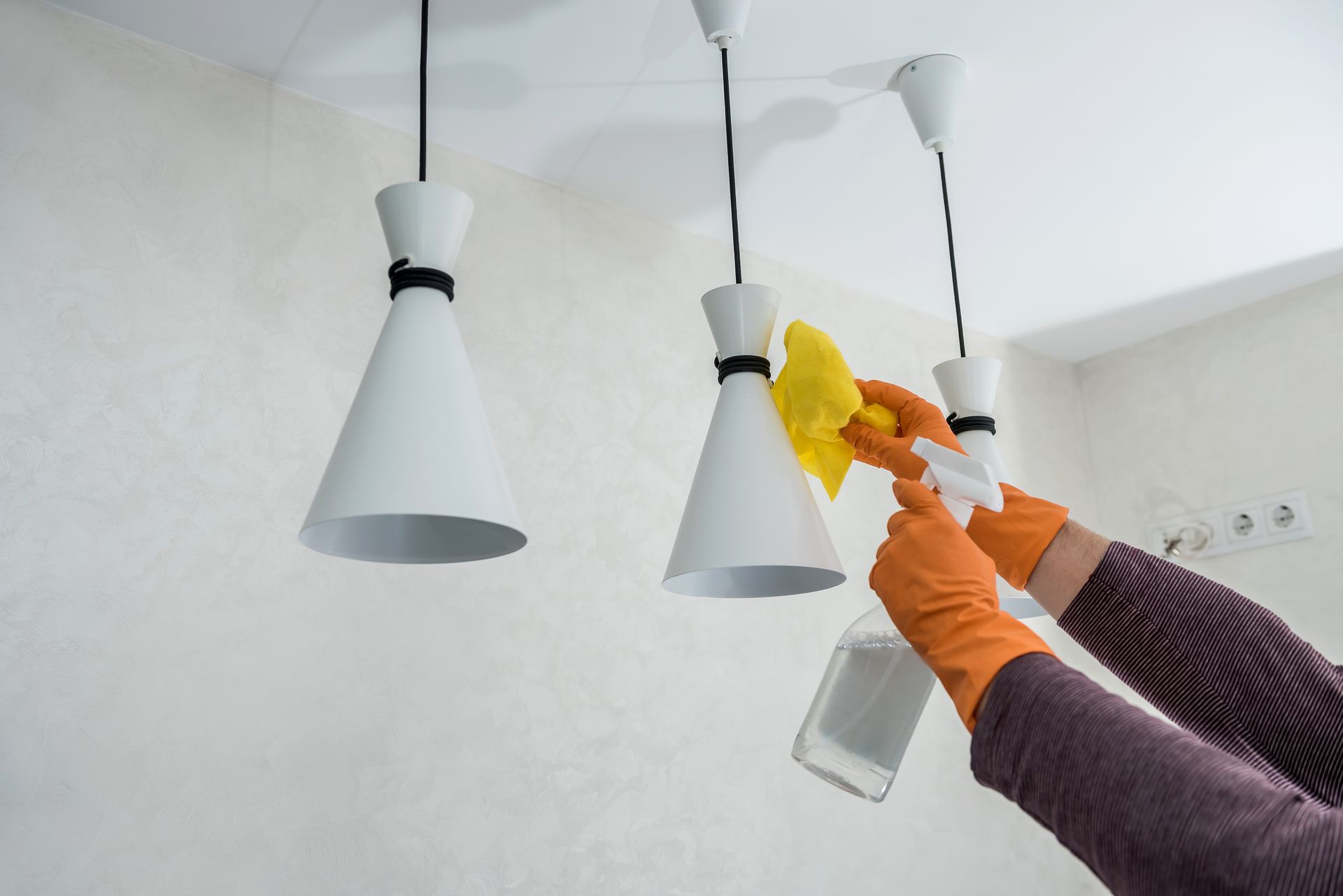 A person is cleaning a ceiling light with a spray bottle and a cloth. - Salisbury, NC - Brumfield Cleaning Company A person is cleaning a ceiling light with a spray bottle and a cloth. - Salisbury, NC - Brumfield Cleaning Company