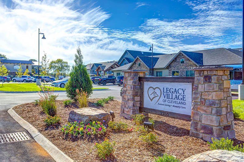 Sign for Legacy Village at a residential community with a blue sky background.