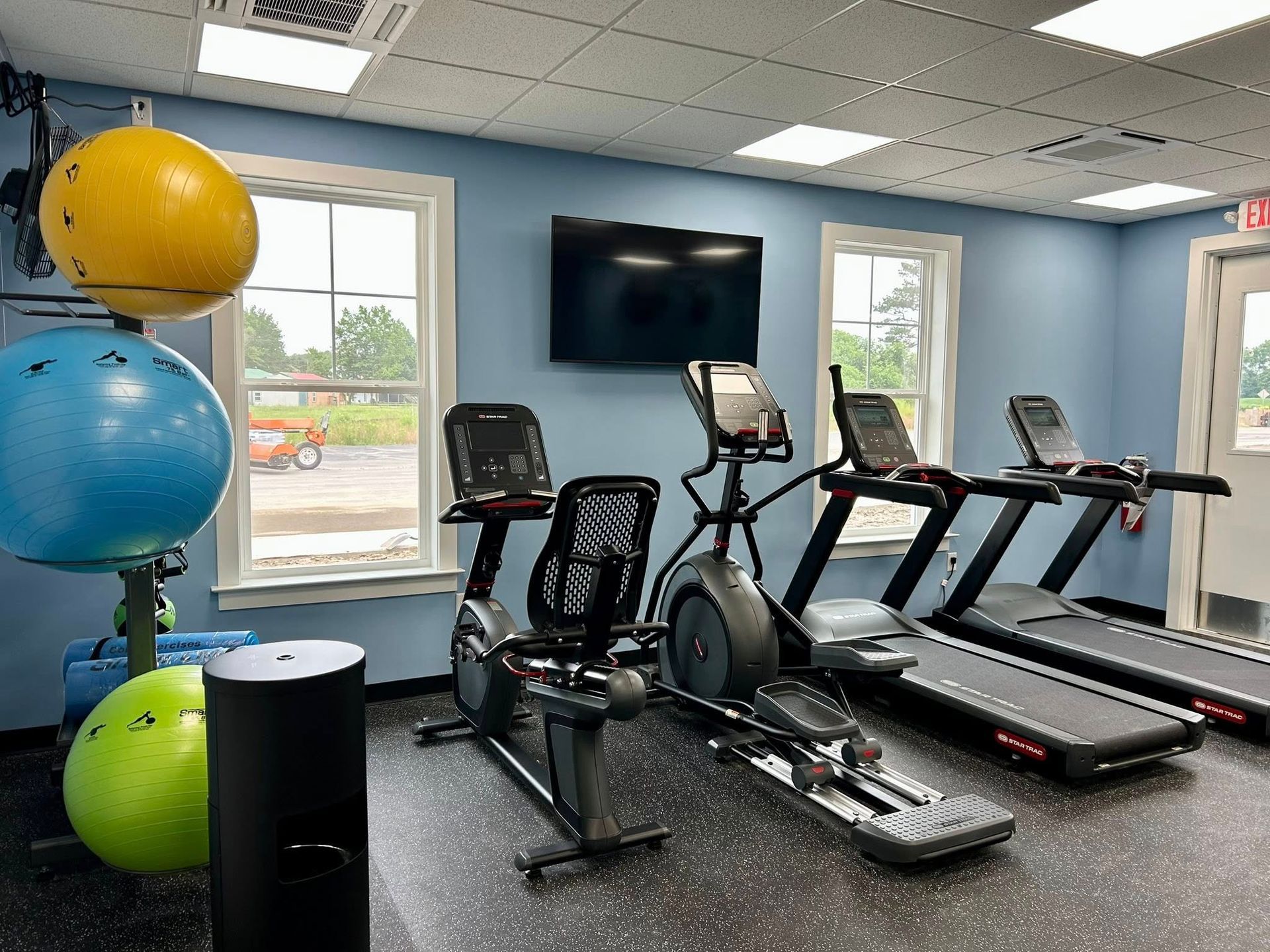 A gym with treadmills , exercise bikes , and a television.