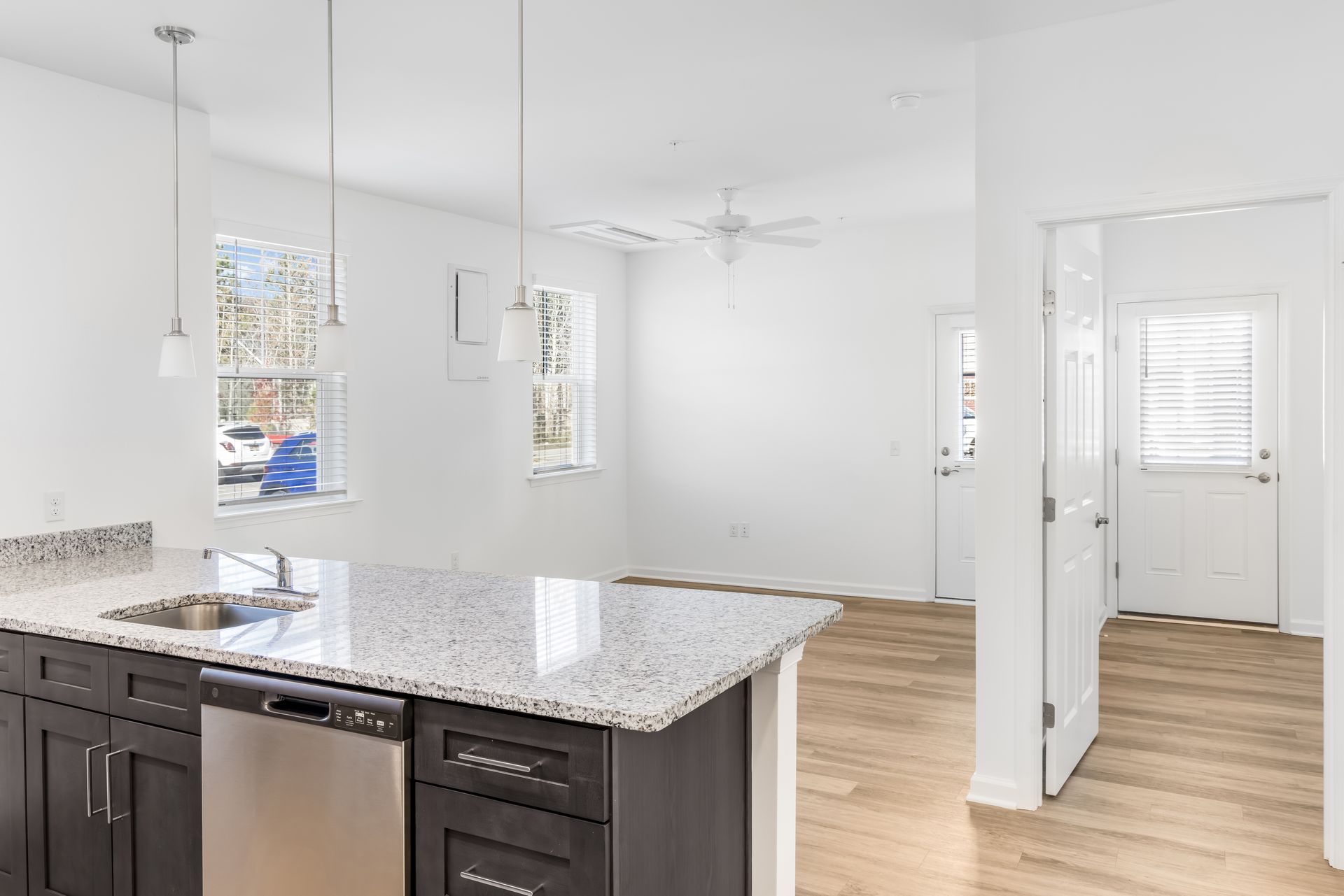 Kitchen with dark cabinets, granite countertop, stainless steel appliances, and wood flooring.