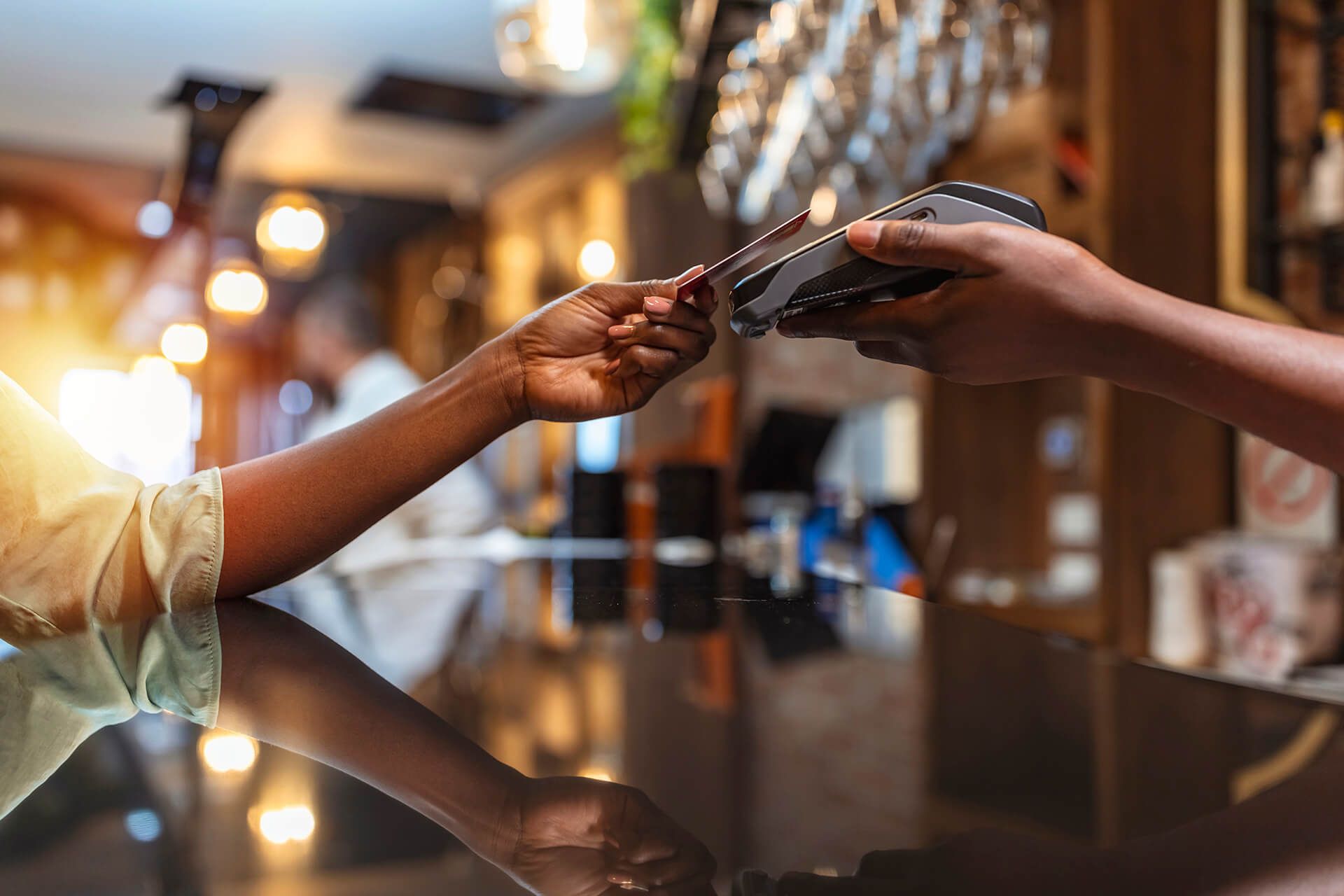 a person is paying with a credit card at a bar .