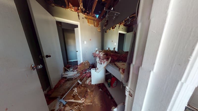 Bathroom before fire damage restoration showing smoke staining on walls ceiling and tile surfaces